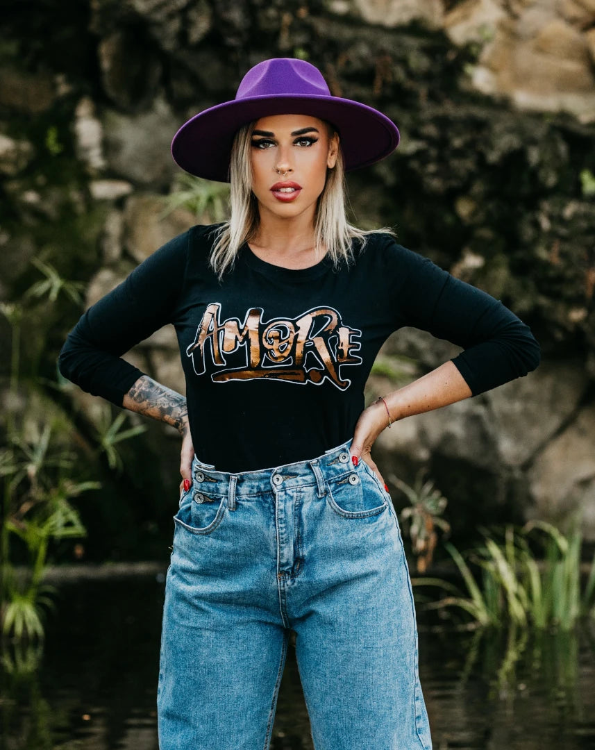 Mujer con gorro morado, jersey con letras oscuro y jeans